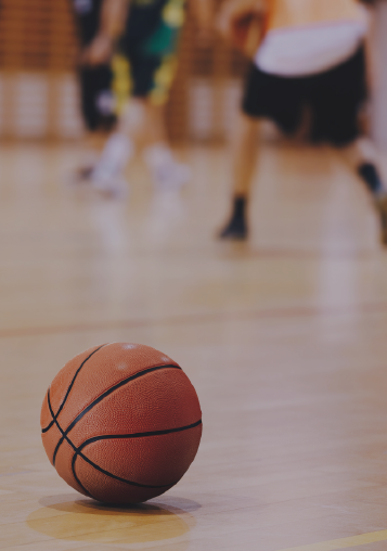 Basketball on the court with people playing in the background - NYSC